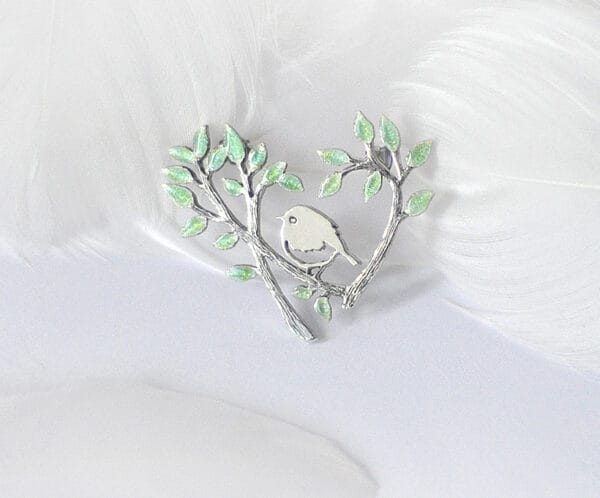 Spring warm The silver enamel brooch “Spring Warmth” shows several early orioles competing for warmth in the trees, reflecting the vitality and vigor of spring