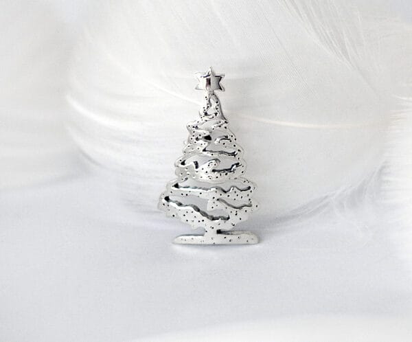 Christmas tree The silver Christmas tree brooch is topped with stars and decorated with snowflakes, showing the festive mood and magic of winter.