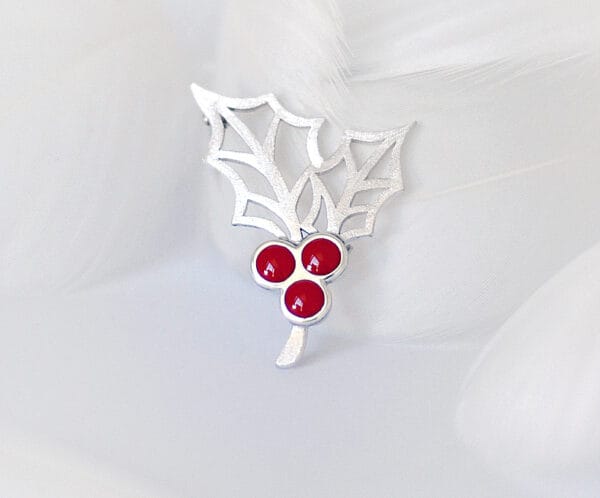 Holly Berry The holly berry brooch decorated with silver and red enamel embodies the vitality and warmth of winter and is suitable for festive wear or daily decoration.