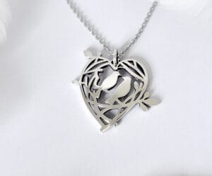 A sweet declaration silver brooch that can also be used as a pendant, showing the love nest of two birds, a design that conveys a warm and loving moment
