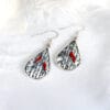 Winter Melody hand-painted enamel earrings, teardrop-shaped asymmetric design featuring a winter scene with poplar trees and red birds, symbolizing the intertwined warmth and cold of a love song.