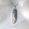Quiet resting places A hand-painted enamel necklace depicting a tranquil deer in a quiet hideaway under the shade of a tree beside a stream, showcasing natural elegance and tranquility, perfect for everyday wear or special occasions.