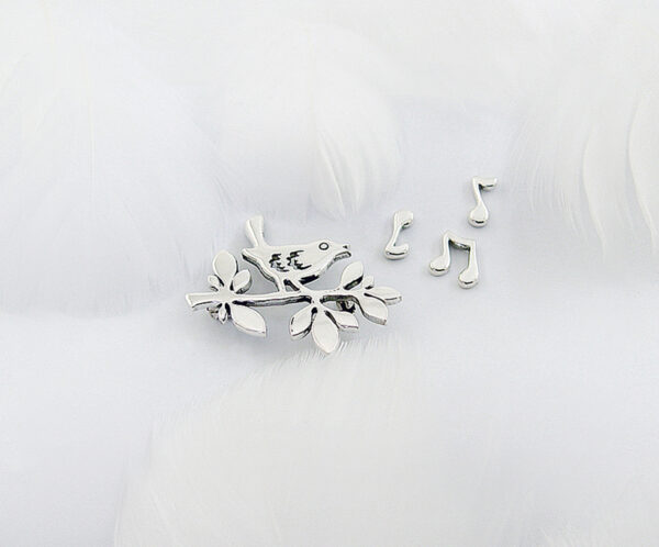A delicate 925 sterling silver brooch set named "Spring Song," featuring a bird perched on a branch with musical notes, symbolizing the vitality and warmth of spring, crafted with fine details and artistic elegance.