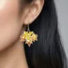 Close-up profile of the model wearing the light-as-maple-wings 'Autumn Rhapsody' enamel earrings. The earrings sway with movement, highlighting the model's face.