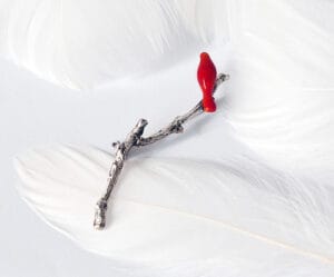 A little red bird perches on a branch. Inspired by Emily Dickinson's poems, the brooch design represents hope and life and is suitable for all occasions.
