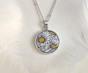 The hand-painted enamel daisy necklace features an exquisite flower pendant and an elegant chain, showcasing a unique artistic style and natural beauty.