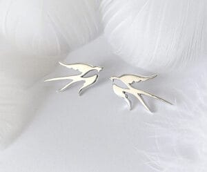 A pair of silver brooches, beautifully displaying a pair of swallows, symbolizing love and happiness, suitable for any occasion.