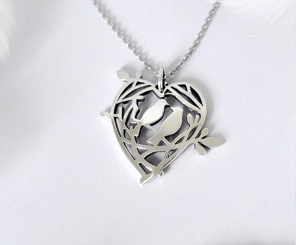 A sweet declaration silver brooch that can also be used as a pendant, showing the love nest of two birds, a design that conveys a warm and loving moment
