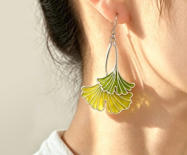 Model wearing Ginkgo Leaf Chartreuse 925 Silver Plique-à-jour Enamel Earrings, handcrafted with translucent vitreous enamel.
