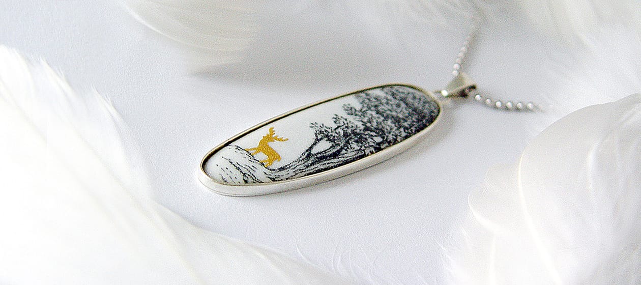a pendant with a picture of a deer on it