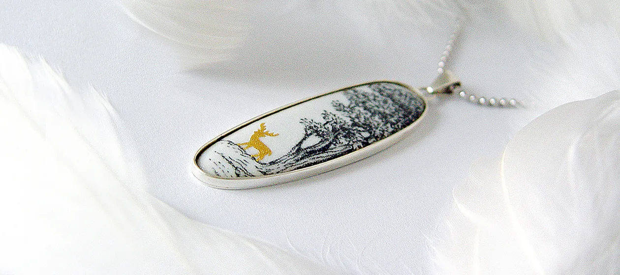 a pendant with a picture of a deer on it
