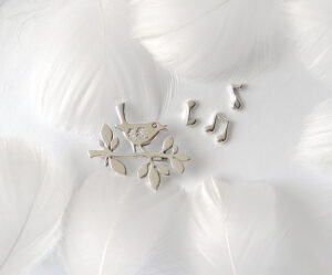 A delicate 925 sterling silver brooch set named "Spring Song," featuring a bird perched on a branch with musical notes, symbolizing the vitality and warmth of spring, crafted with fine details and artistic elegance.