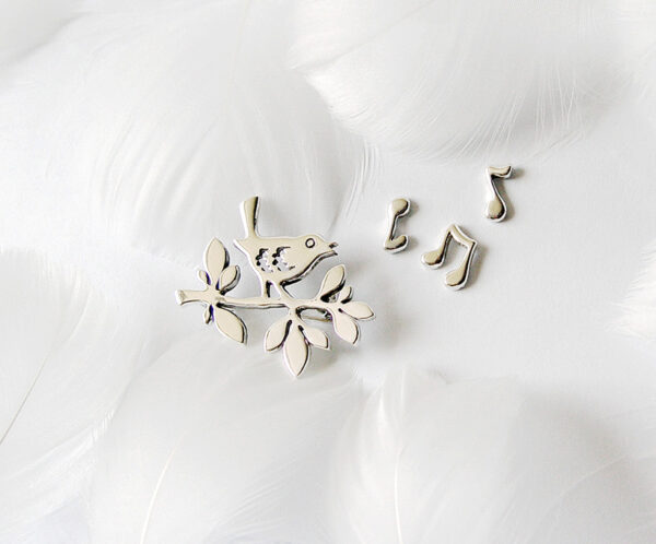 A delicate 925 sterling silver brooch set named "Spring Song," featuring a bird perched on a branch with musical notes, symbolizing the vitality and warmth of spring, crafted with fine details and artistic elegance.