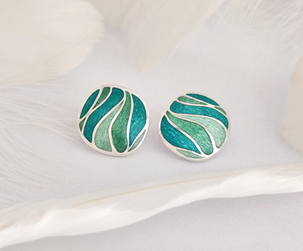 Handcrafted enamel stud earrings inspired by “Still waters run deep,” with blue-green tones and engraved silver. Elegant for daily wear or as a thoughtful gift.